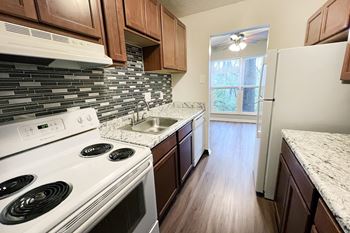 A kitchen with a white stove top oven and a white refrigerator.